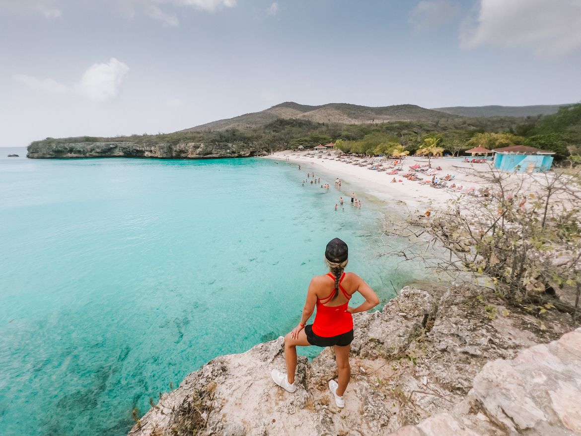 westpunt grote knip strand en een vrouw die op de klip staat