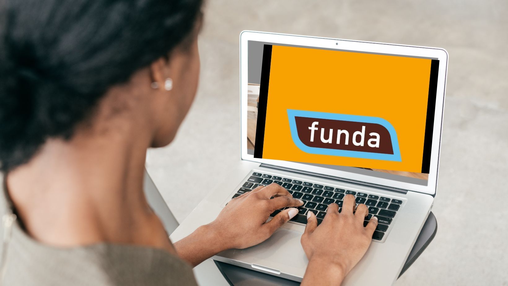 vrouw achter laptop met funda curacao op het scherm van de makelaar